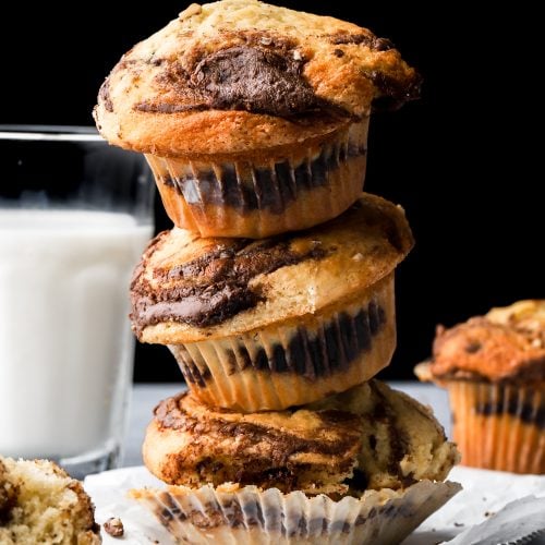 3 stacked nutella muffins next to a cup of milk