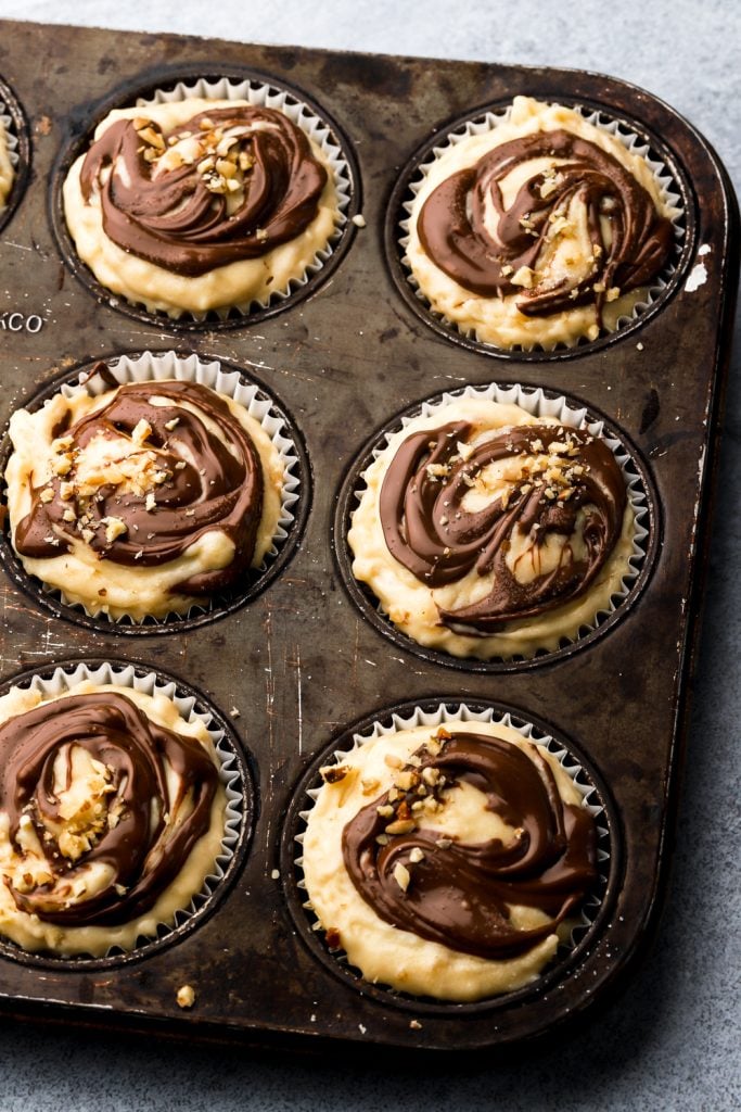 swirled nutella on top of muffin batter in a pan