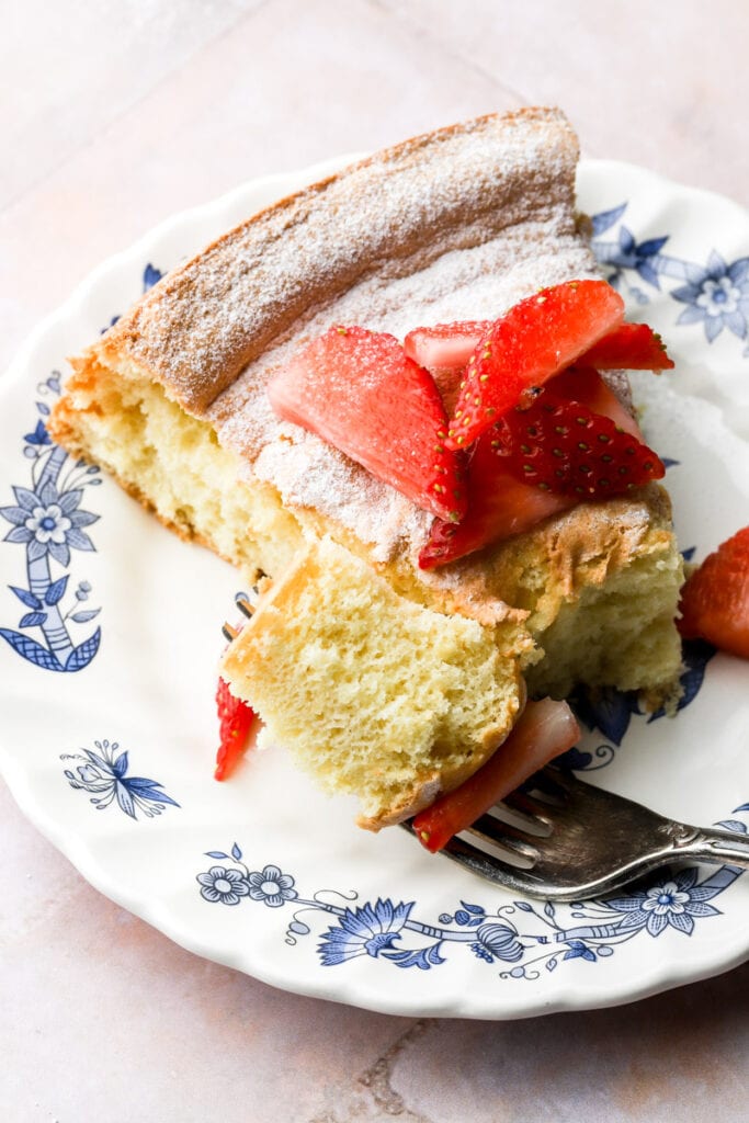 slice of cake on a plate with a fork and a bite taken out