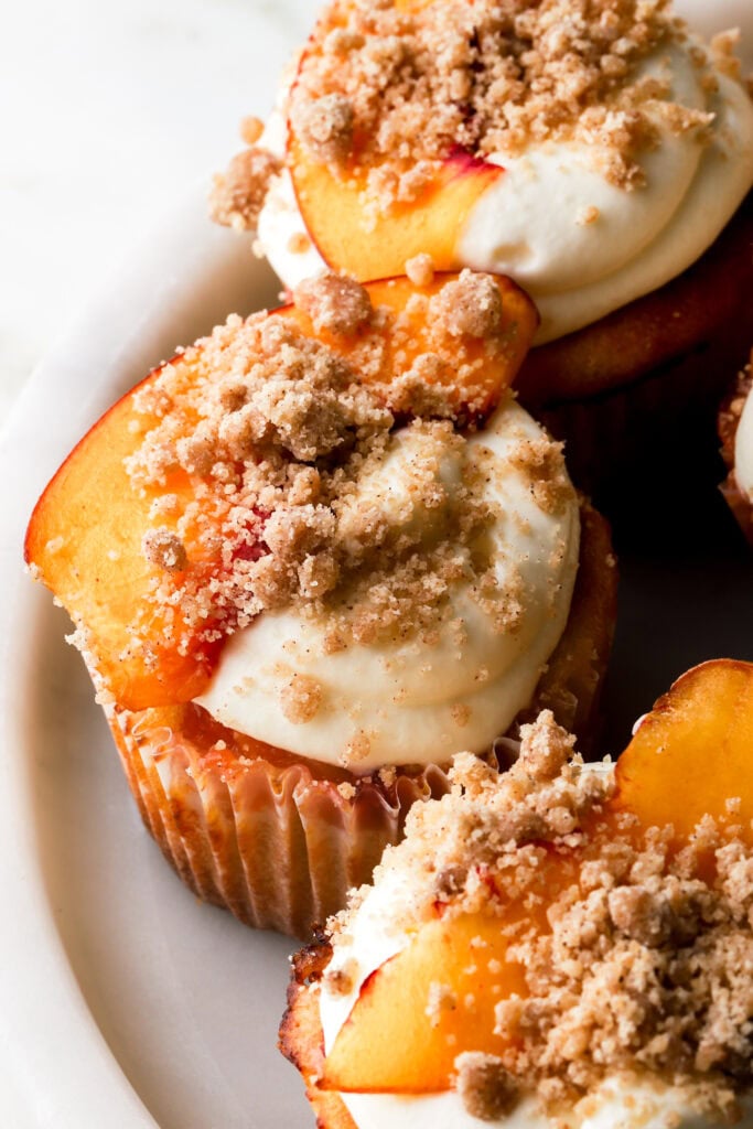 peach cobbler cupcakes topped with fresh slice of peach and streusel