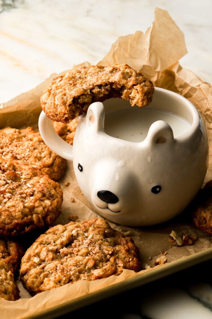 pecan oatmeal cookies with a bite taken out and a glass of milk