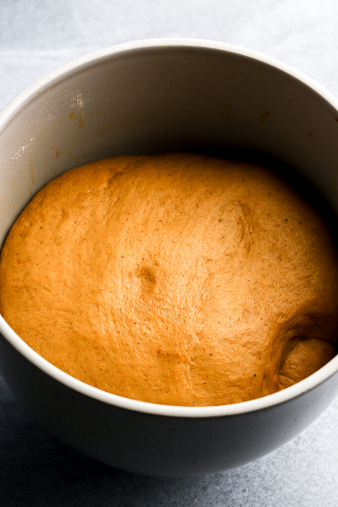 pumpkin cinnamon roll dough after it proofs and grows in size in bowl