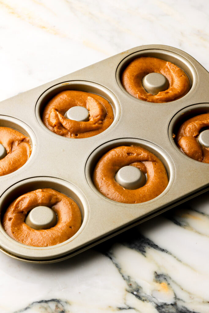 batter piped into donuts molds