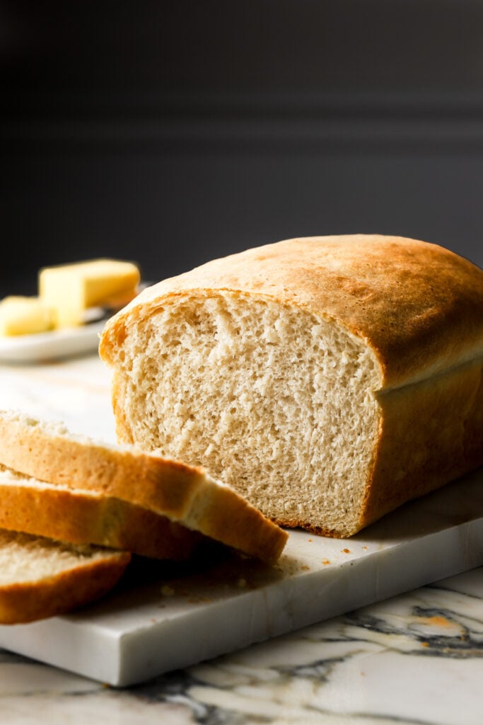 sandwich loaf sliced with butter in the background