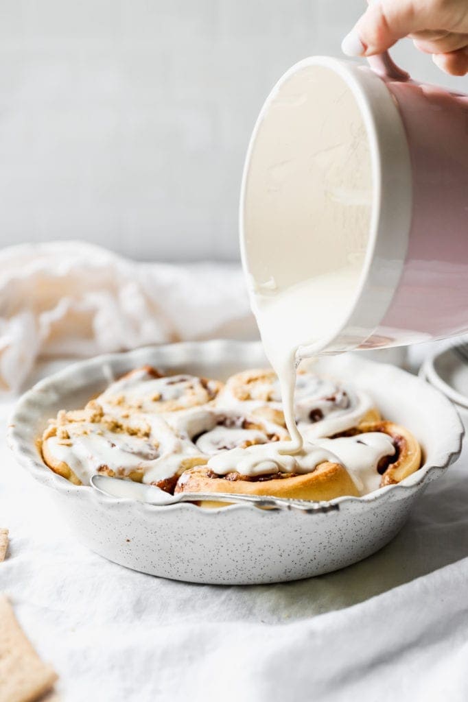 pouring marshmallow fluff over s'mores rolls