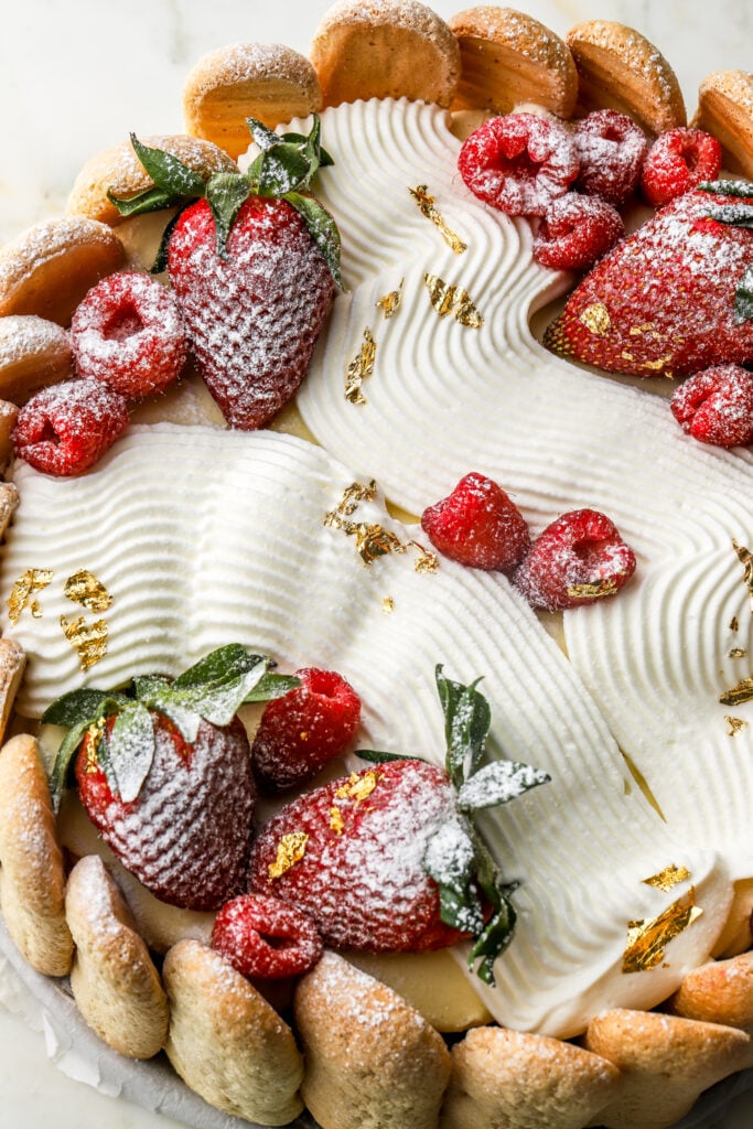pipe whipped cream onto chilled cake and top with fresh strawberries