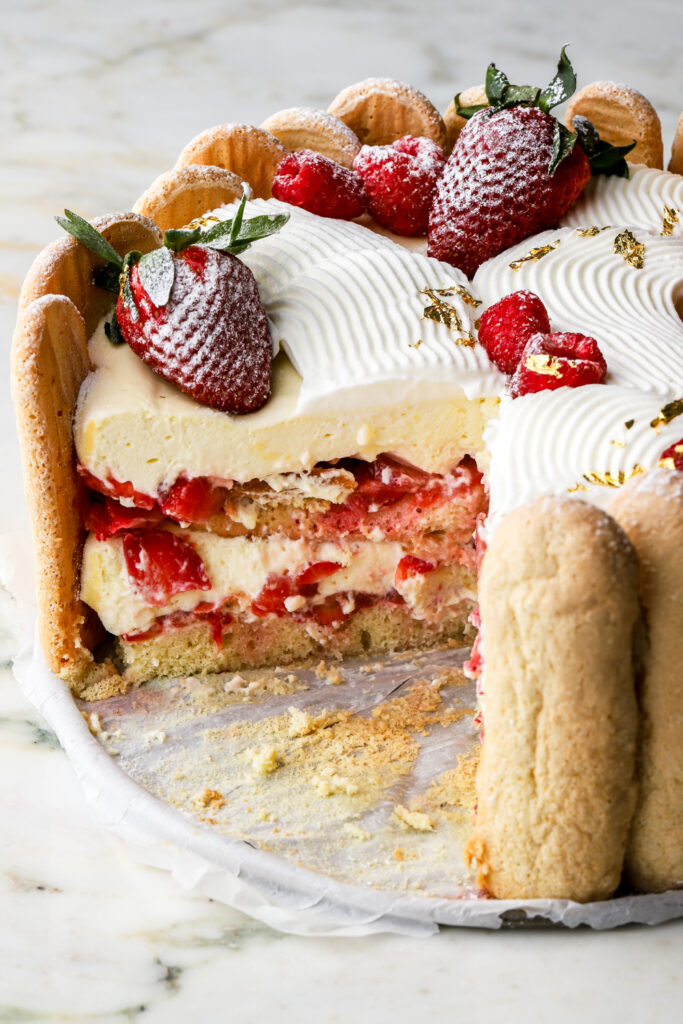 strawberry charlotte cake with a slice missing