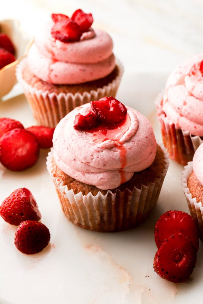 strawberry cupcakes topped with fresh strawberry slices