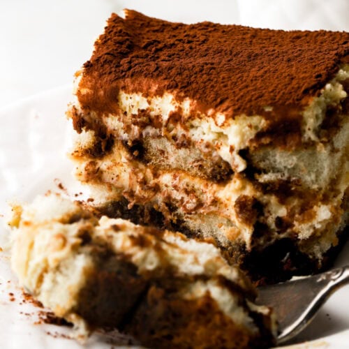 tiramisu on a plate with a bite taken out