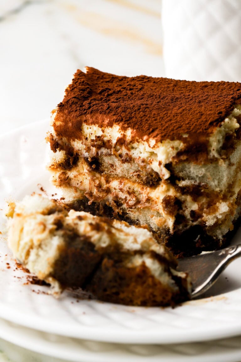 tiramisu on a plate with a bite taken out