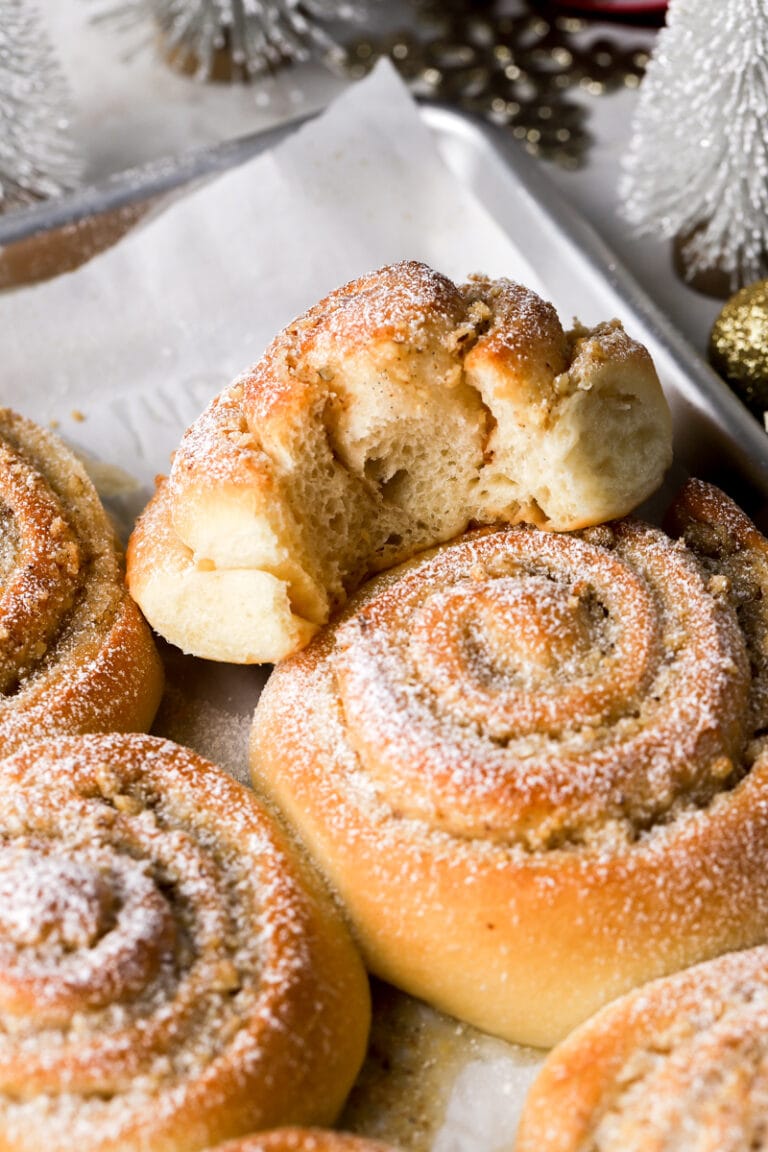 vanilla walnut roll dusted with powdered sugar and a bite taken out