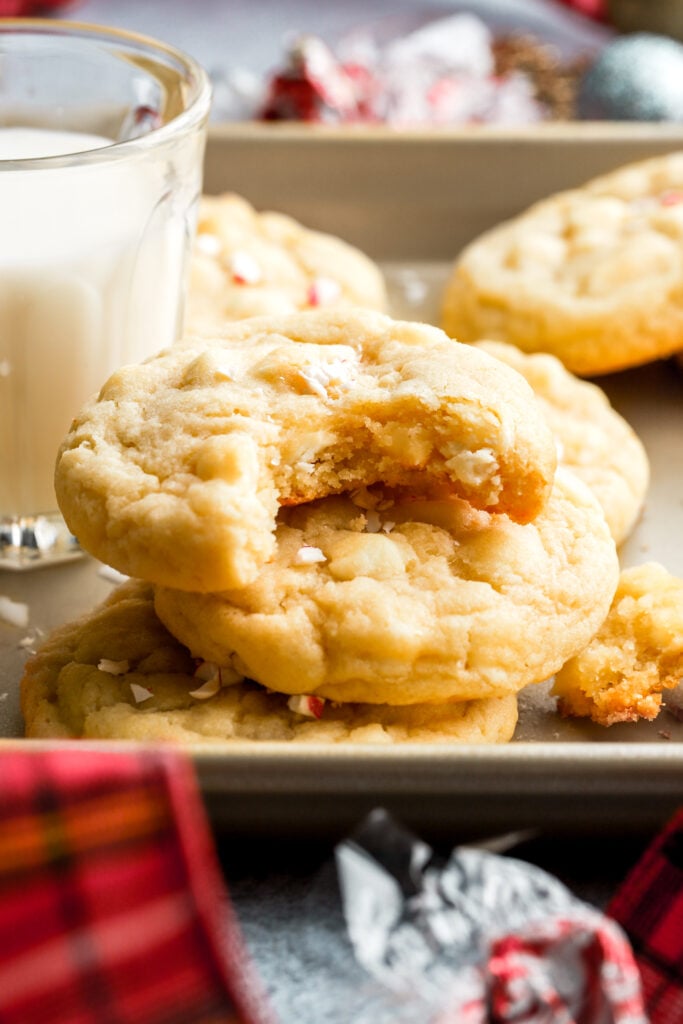 white chocolate peppermint cookies stacked by a glass of milk