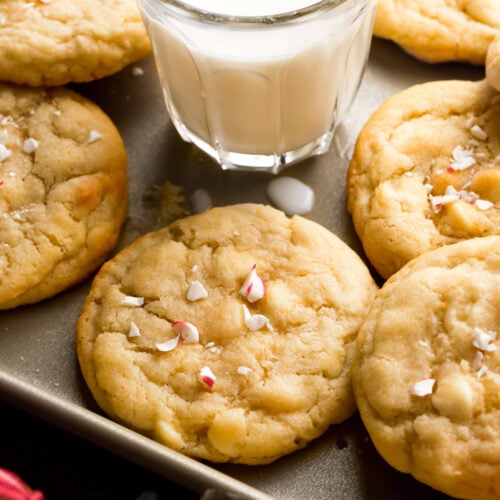 white chocolate peppermint cookies on a tray with a glass of milk