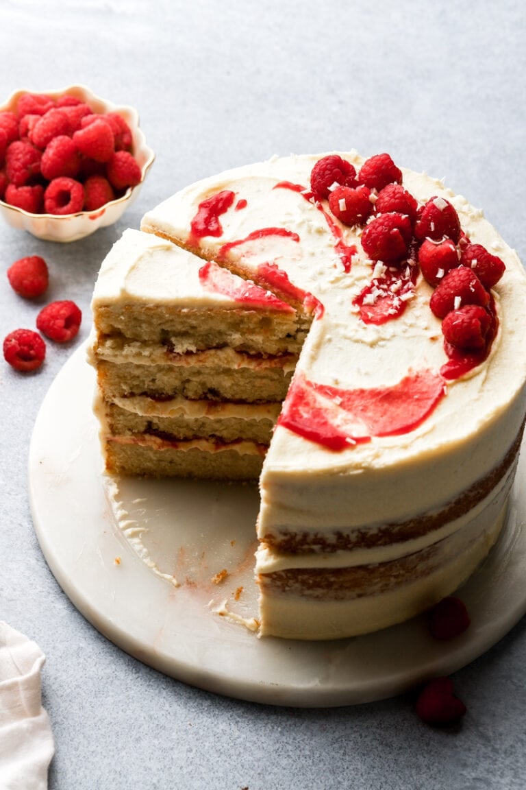 white chocolate raspberry cake with a slice taken out