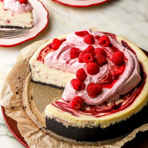 inside of a white chocolate raspberry cheesecake with slices next to it