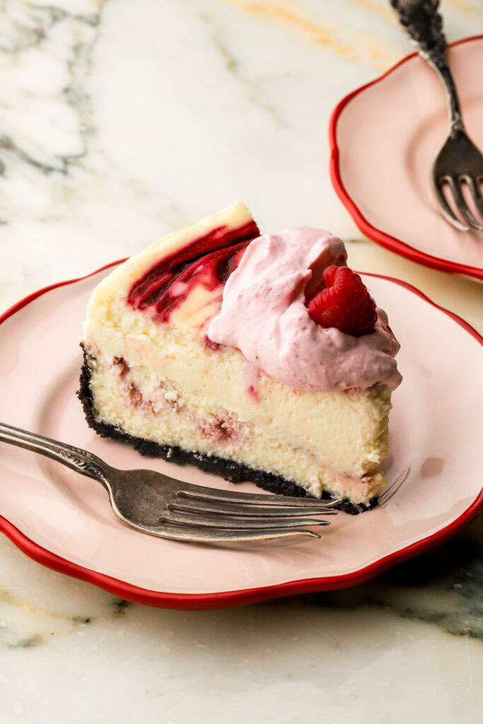 close up of a slice of white chocolate raspberry cheesecake