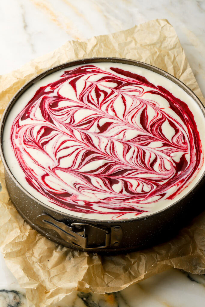 second half of cheesecake batter poured in and swirled with raspberry sauce