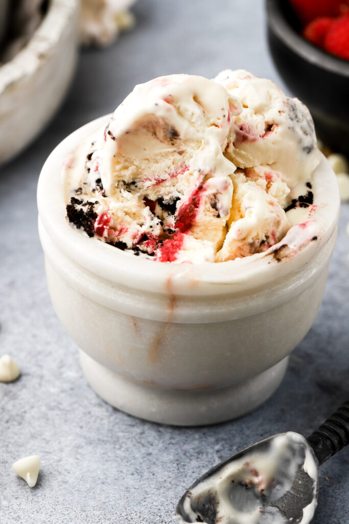 white chocolate raspberry ice cream in a bowl with a bite taken out
