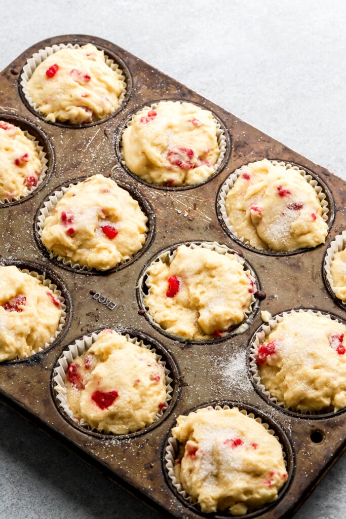 muffin pan filled with white chocolate raspberry muffin batter