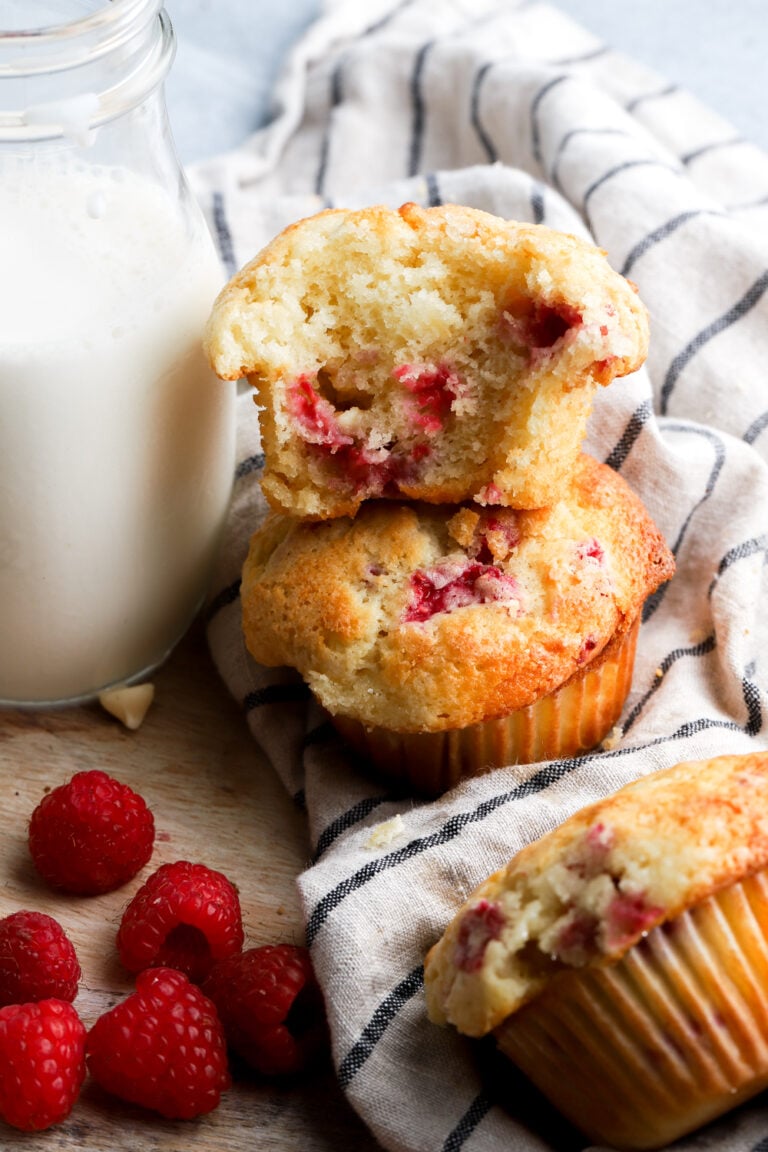 white chocolate raspberry muffins stacked with a bite taken out